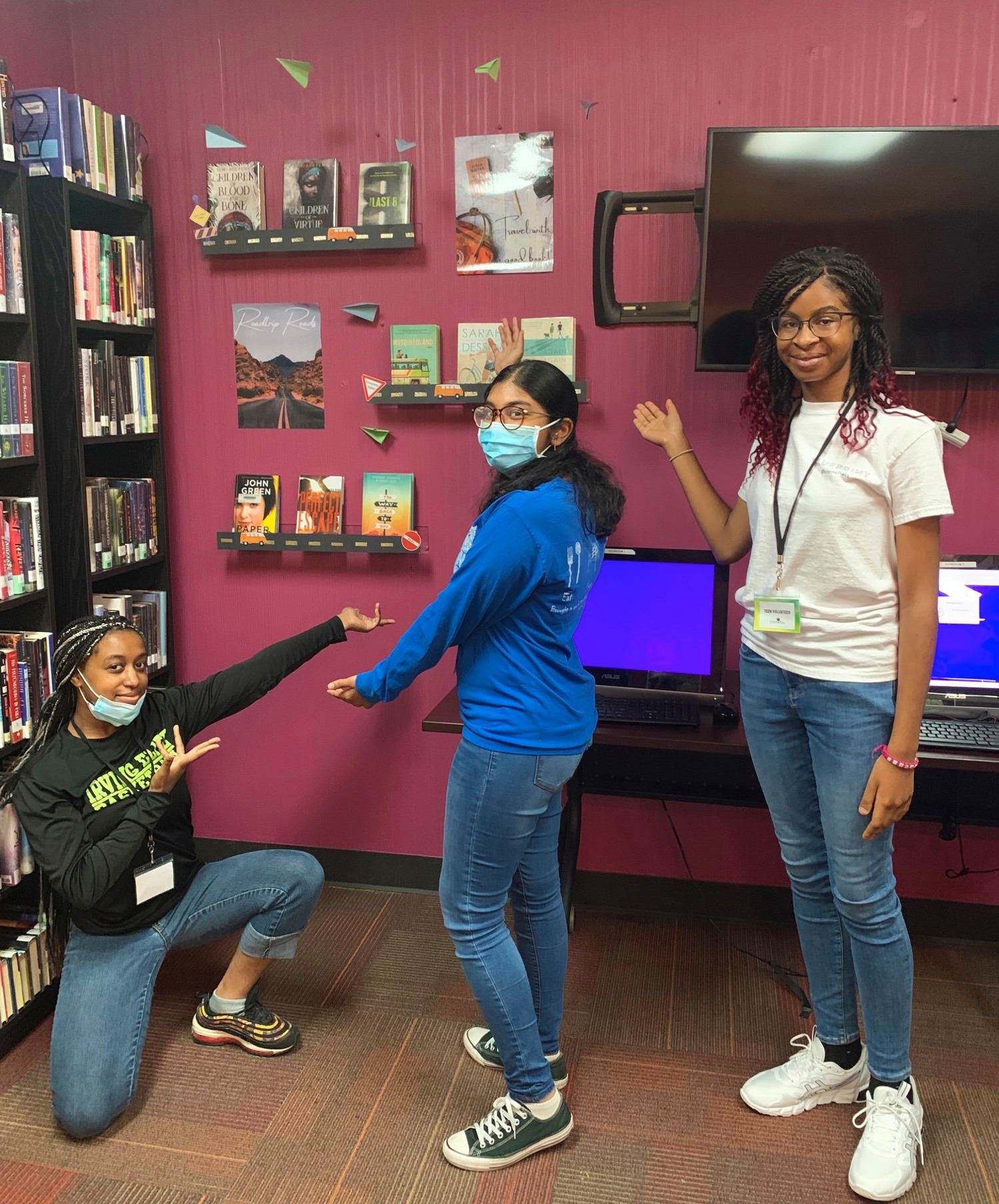 Teen Volunteers Gesturing to Book Display